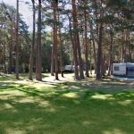 Zona de acampada, con una mobile-home en una pradera verde