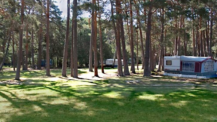 Zona de acampada, con una mobile-home en una pradera verde