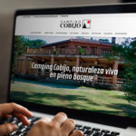 Persona en ordenador portátil viendo la nueva web del Camping Cobijo
