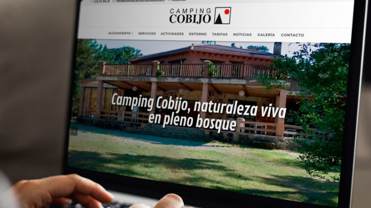 Persona en ordenador portátil viendo la nueva web del Camping Cobijo